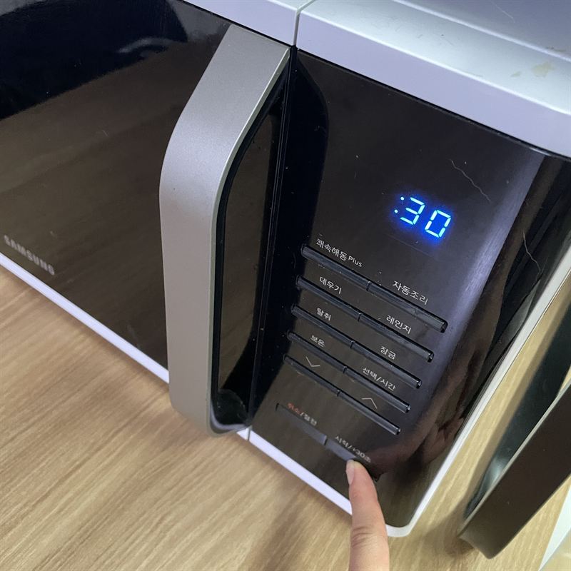 전자레인지에 30초가 표시된 상태에서 시작/+30초 버튼을 누르는 모습