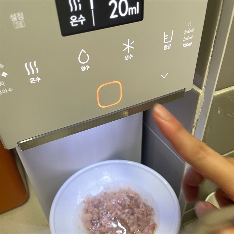 정수기에서 온수 20ml를 받는 모습